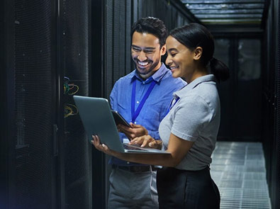 Two smiling colleagues working in a data center