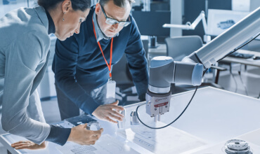 Two engineers with microscope over table