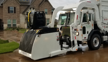 Garbage truck picking up curbside