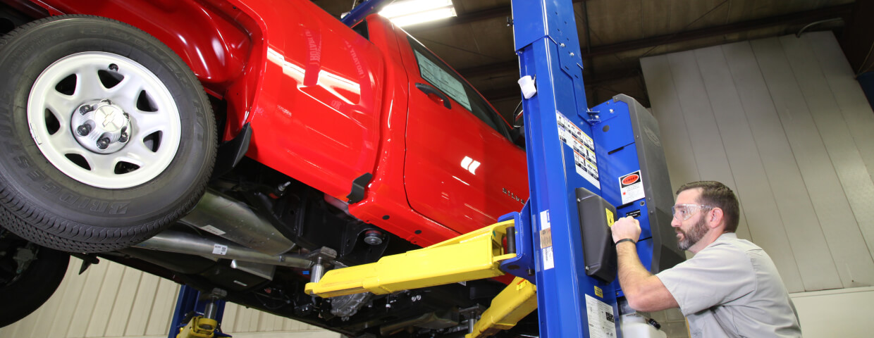 Man working working on a truck on a lift