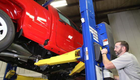 Man working working on a truck on a lift